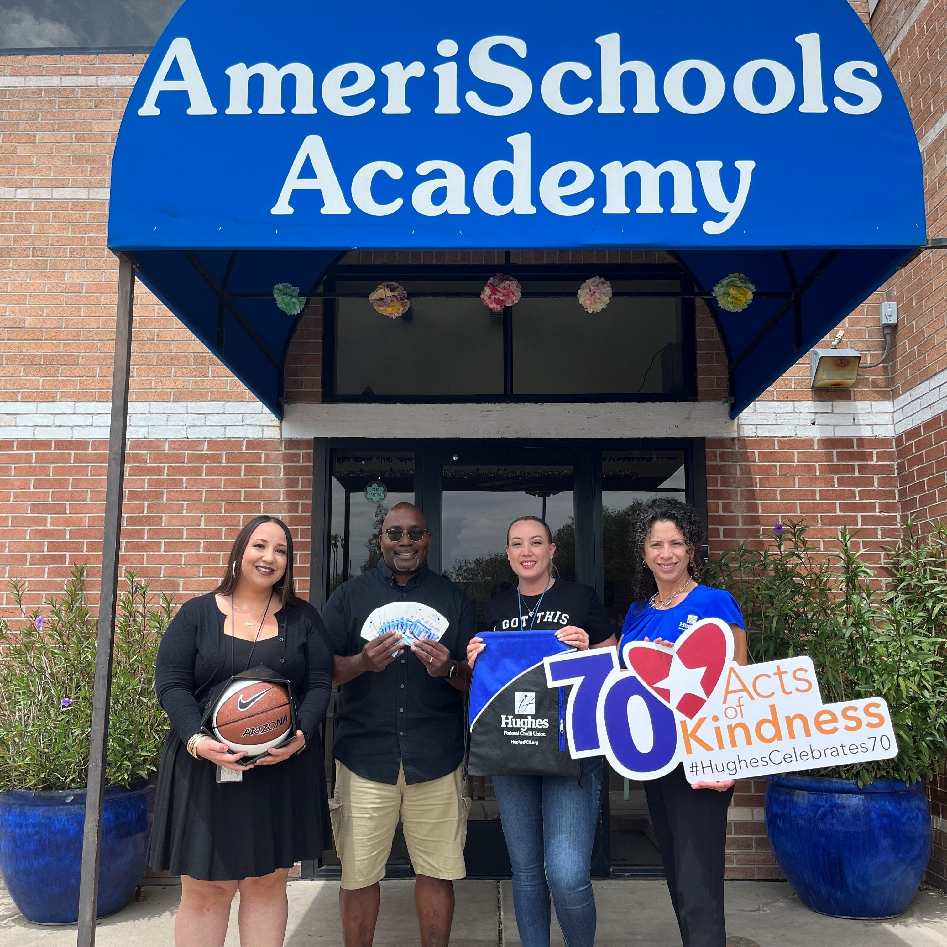 The Hughes Team poses with AmeriSchool teachers with gift cards and basketball