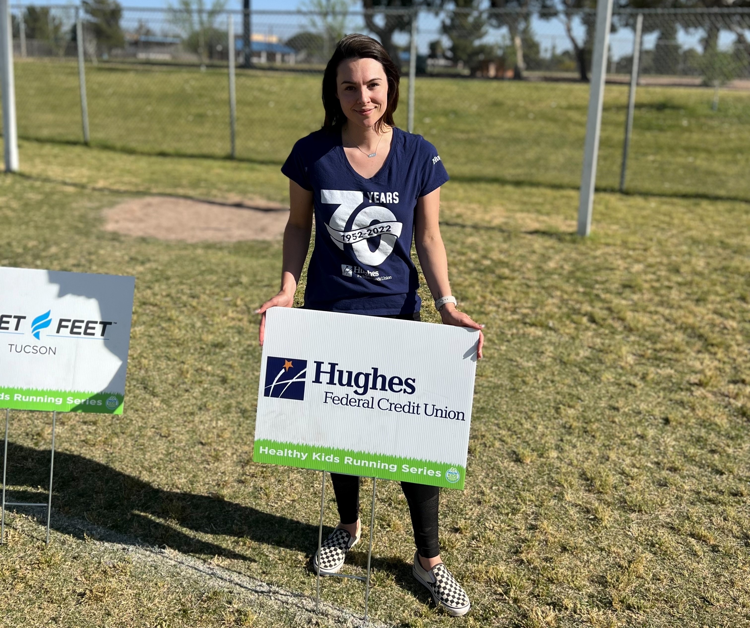 Hughes employee holds sponsor sign