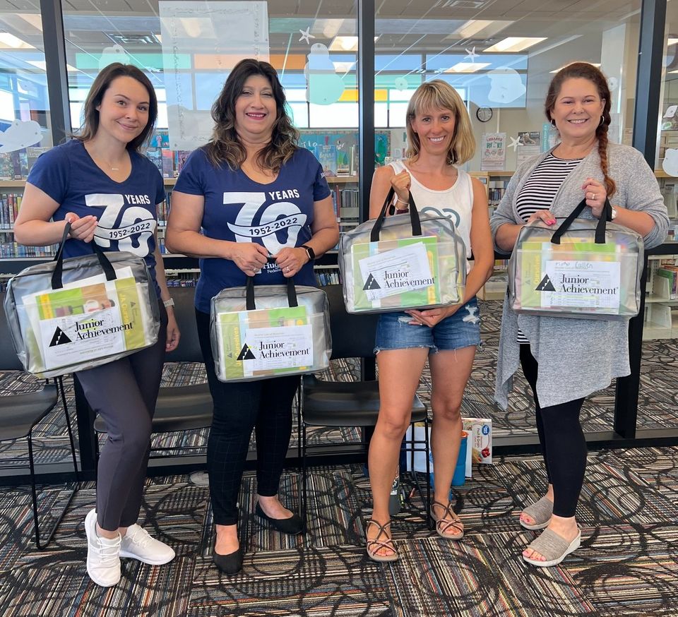 The Hughes Team and volunteers hold financial literacy bags
