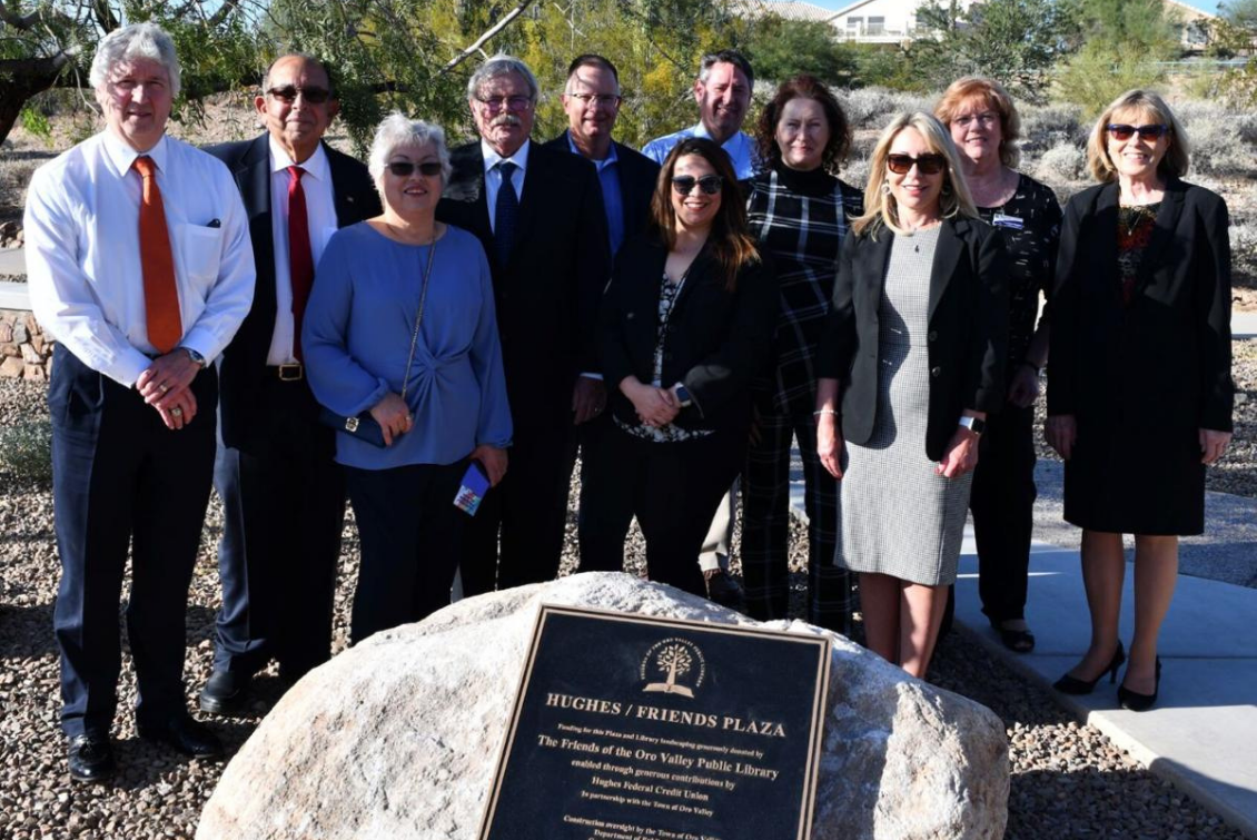 The Hughes Federal Credit team is gathered around a Hughes/Friends Plaza dedication plaque