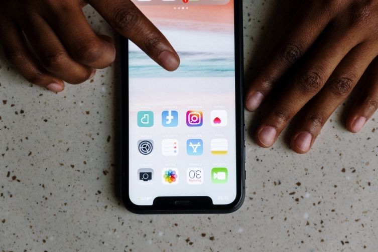 Two hands navigate through phone apps