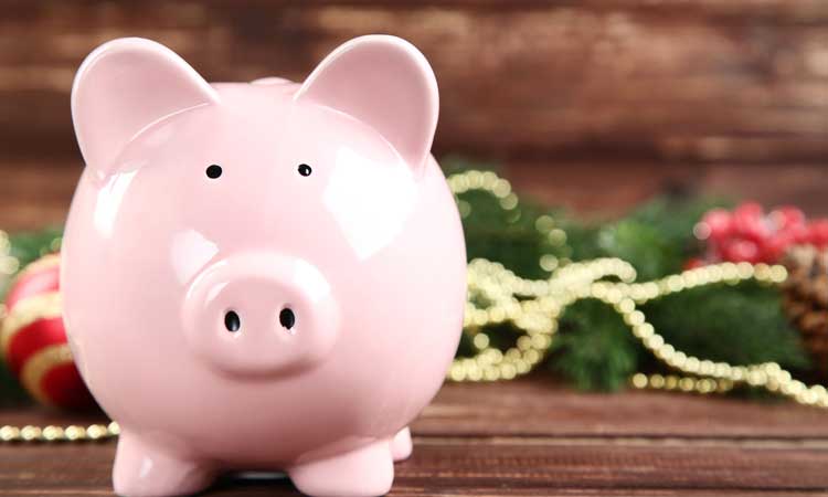 Smiling piggy bank with Christmas decor in the background