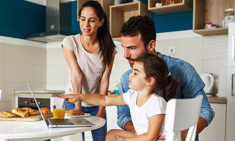 young family looking at laptop