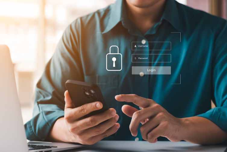 Man in blue green shirt hold phone in hand with icons of a login screen superimposed.