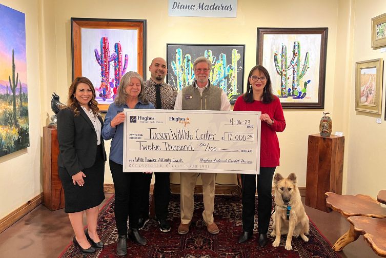 The Hughes team, Diana Madaras alongside her dog, and representatives from the Tucson Wildlife pose with a giant check.