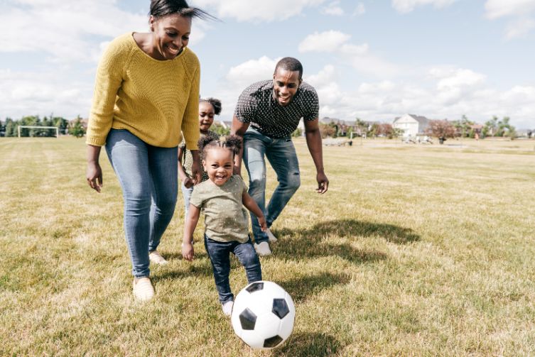 A family plays soccer at the park