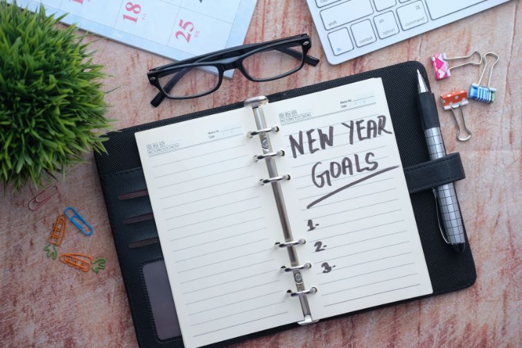 A notebook with the words, "New Year Goals" written on it.