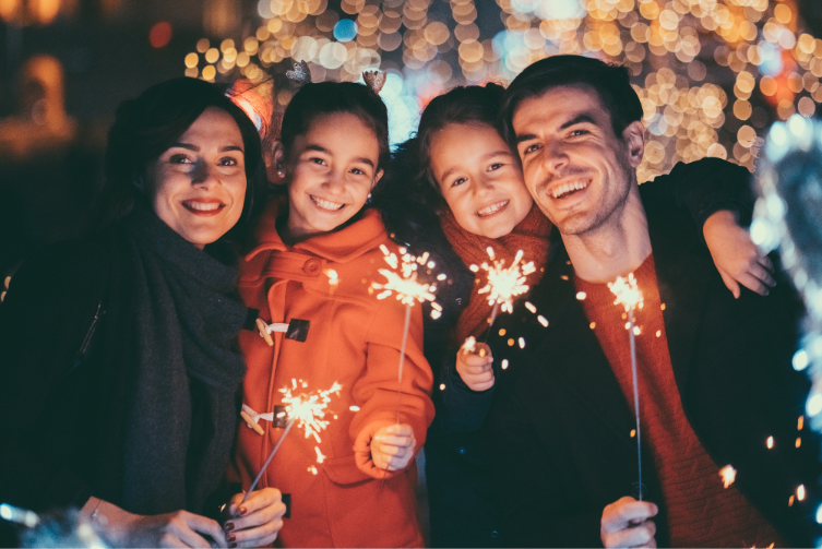 Una familia sosteniendo bengalas celebrando el Año Nuevo