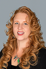 Head shot of smiling woman with curly red hair.
